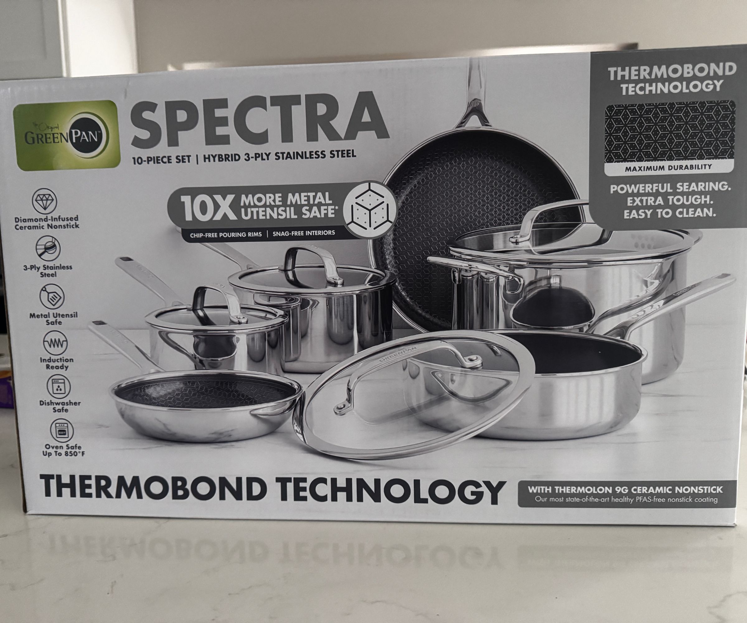 The full Greenpan Spectra Thermobond pan set in the white box on a kitchen counter.