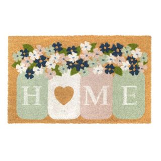 A brown welcome mat with a pink and mint sign saying 'home'
