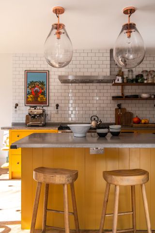 Yellow kitchen with white splashback tiles