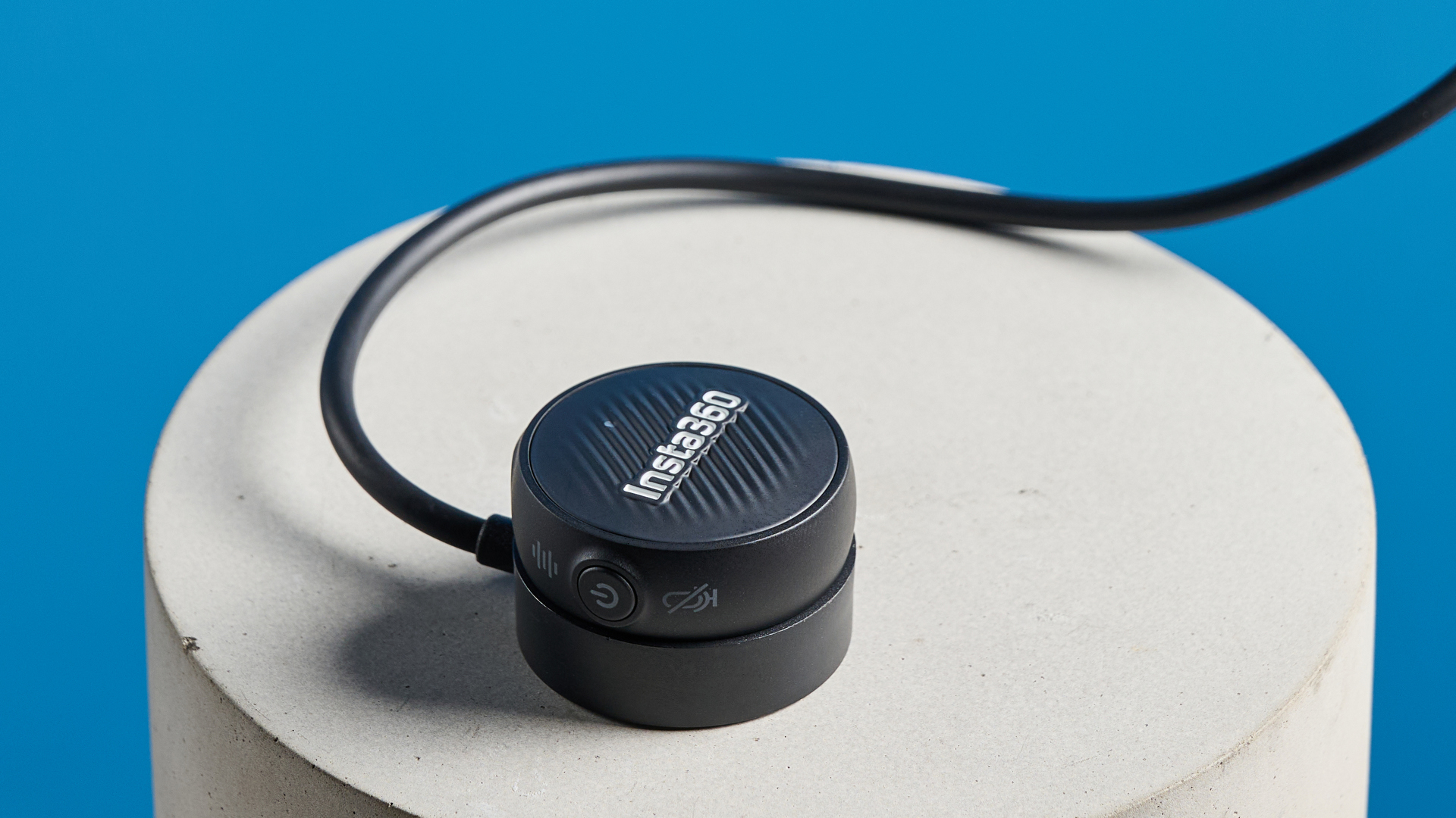 Insta360 Mic Air photographed on a blue background
