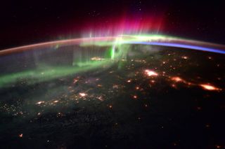 This is a view of a beautiful aurora as seen from the International Space Station. The bright pink, green and blue lights of the aurora dance over the Pacific Northwest, creating not only a spectacular light show for those on Earth, but for those on the s