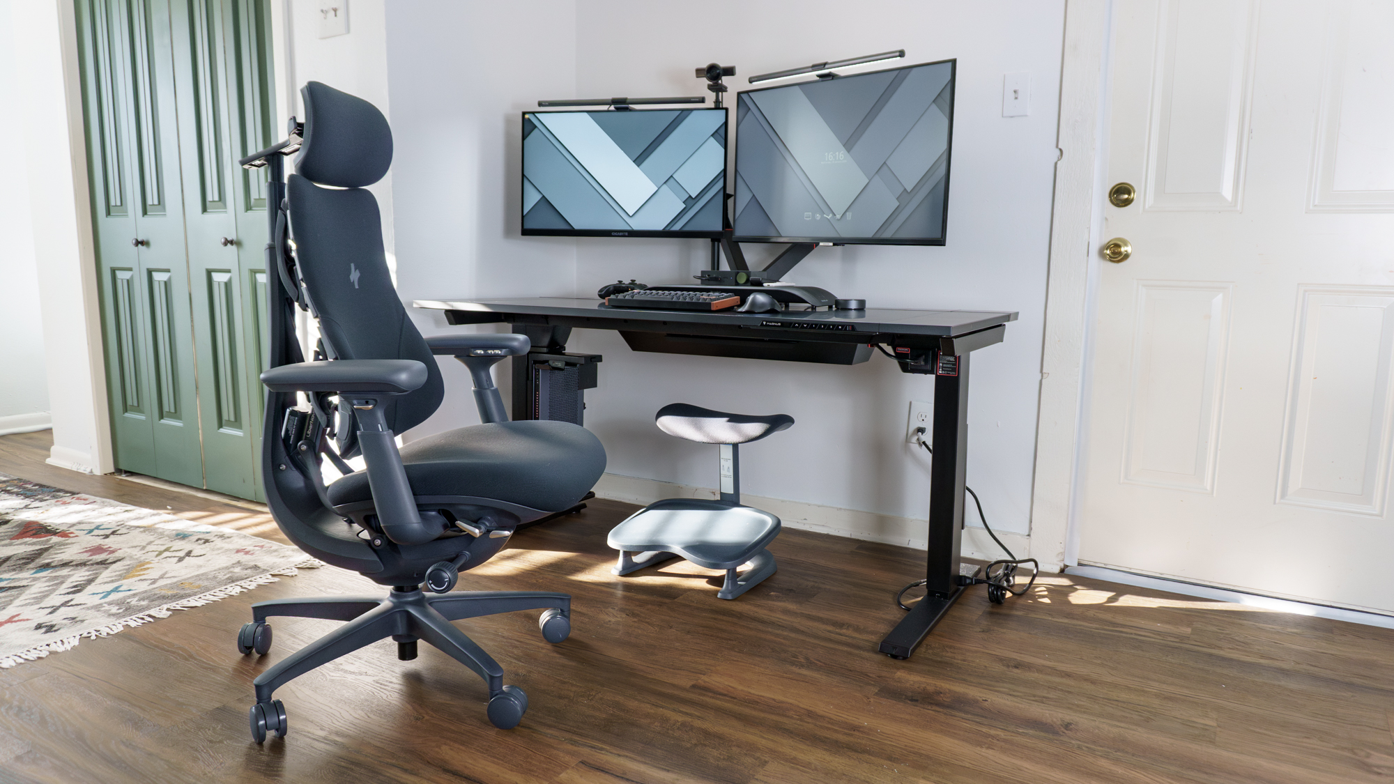 A wideshot of the LiberNovo Omni office chair and StepSync footrest in front of a dual-monitor desk setup
