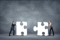 Two gentlemen pushing puzzle pieces together