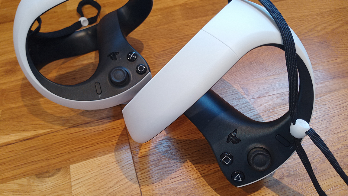 PSVR 2 review; two white and black VR controllers on a wooden table