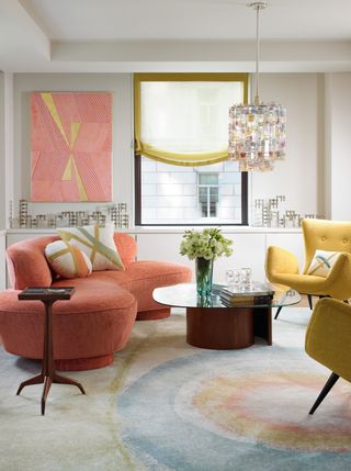 a colorful living room with a red sofa, yellow chair and patterned rug