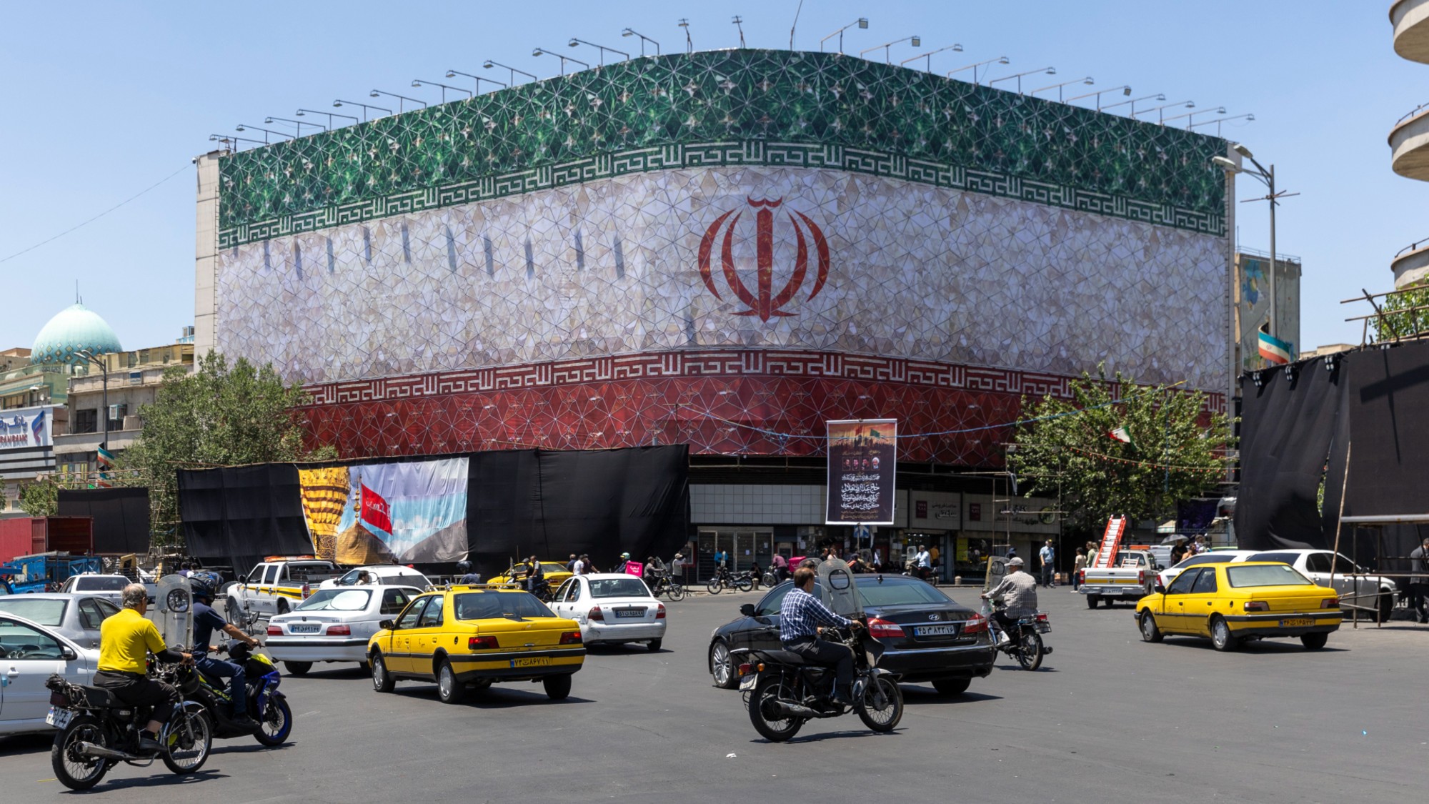 Vehicles drive through a square in Tehran, Iran