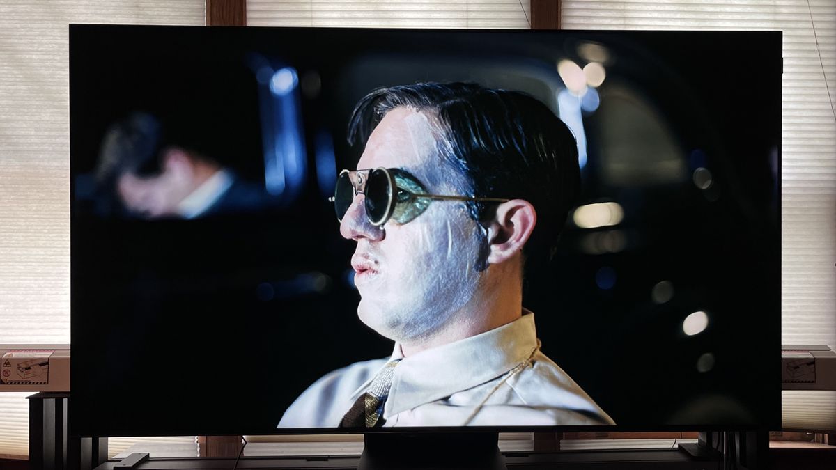 TCL QM851G TV showing image of man wearing sunglasses