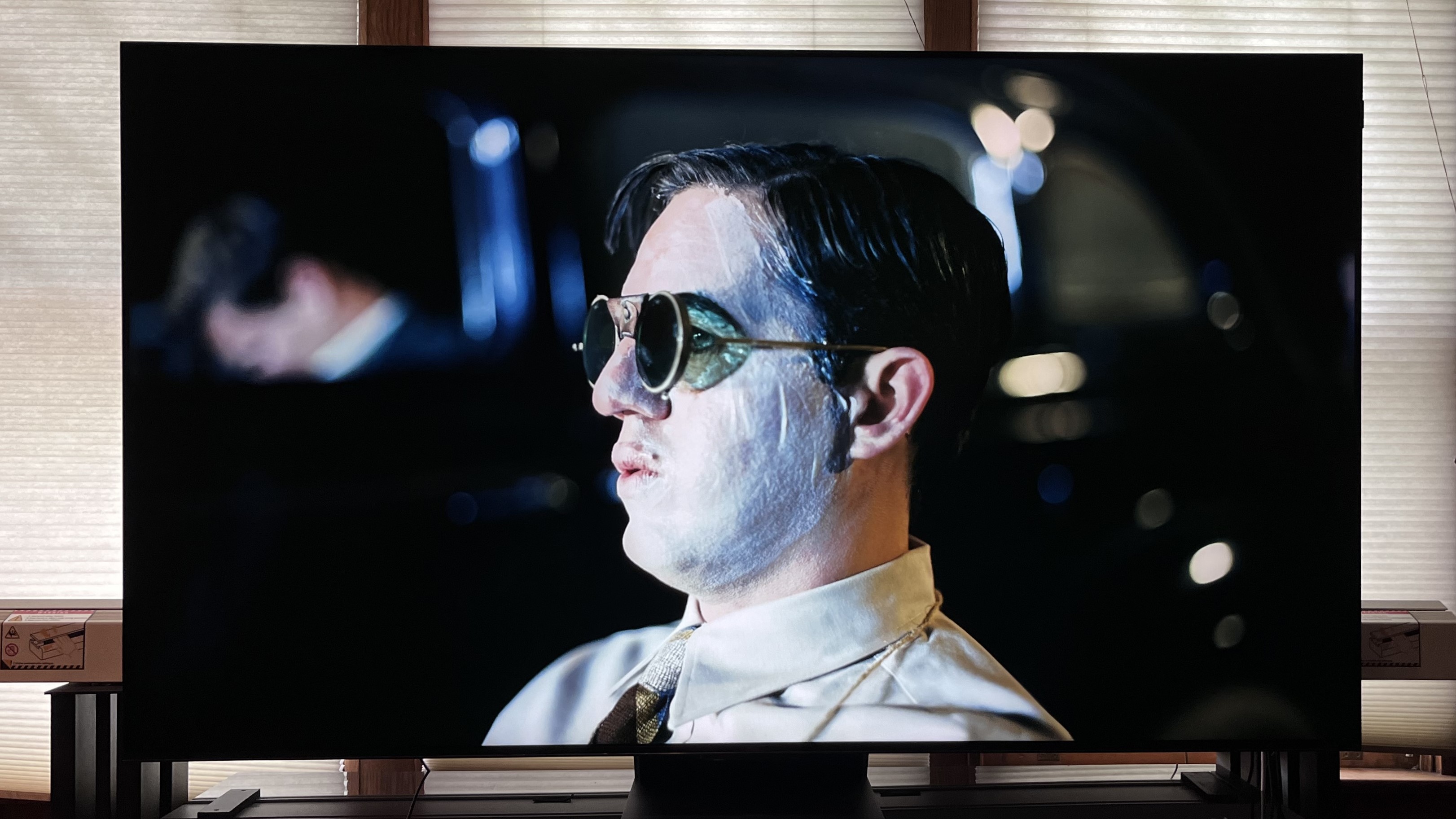 TCL QM851G TV showing a picture of a man wearing sunglasses