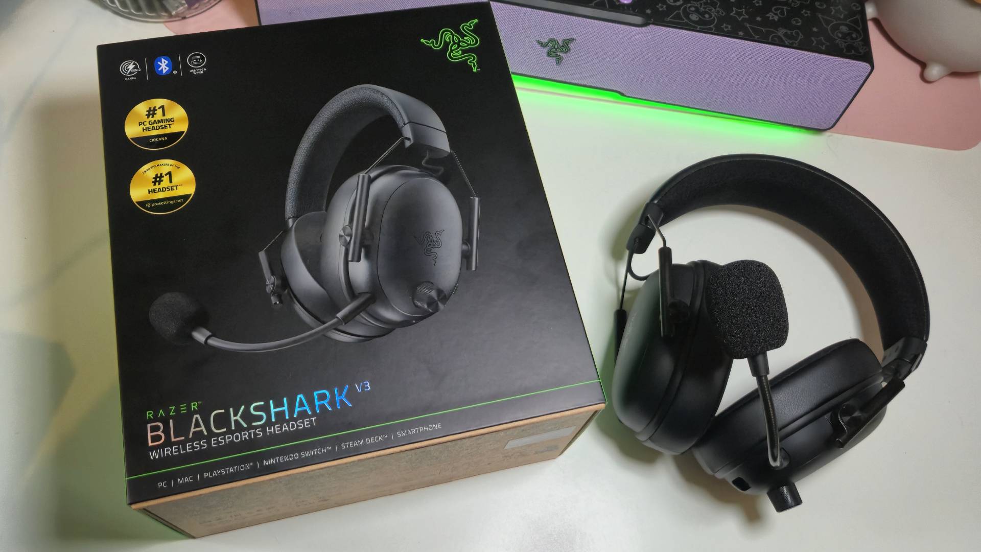 Photo by Rosalie Newcombe of the Razer BlackShark V3 gaming headset sitting on a white desk with its box on the left hand side.