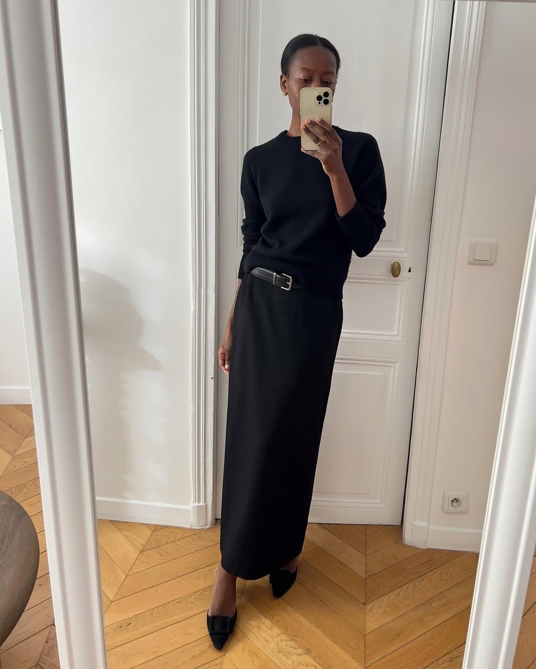 Influencer Slyvie Mus wearing an anti-trend outfit of black jumper, pencil skirt and kitten heels.