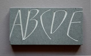 Grey stone with ABIDE carved in white