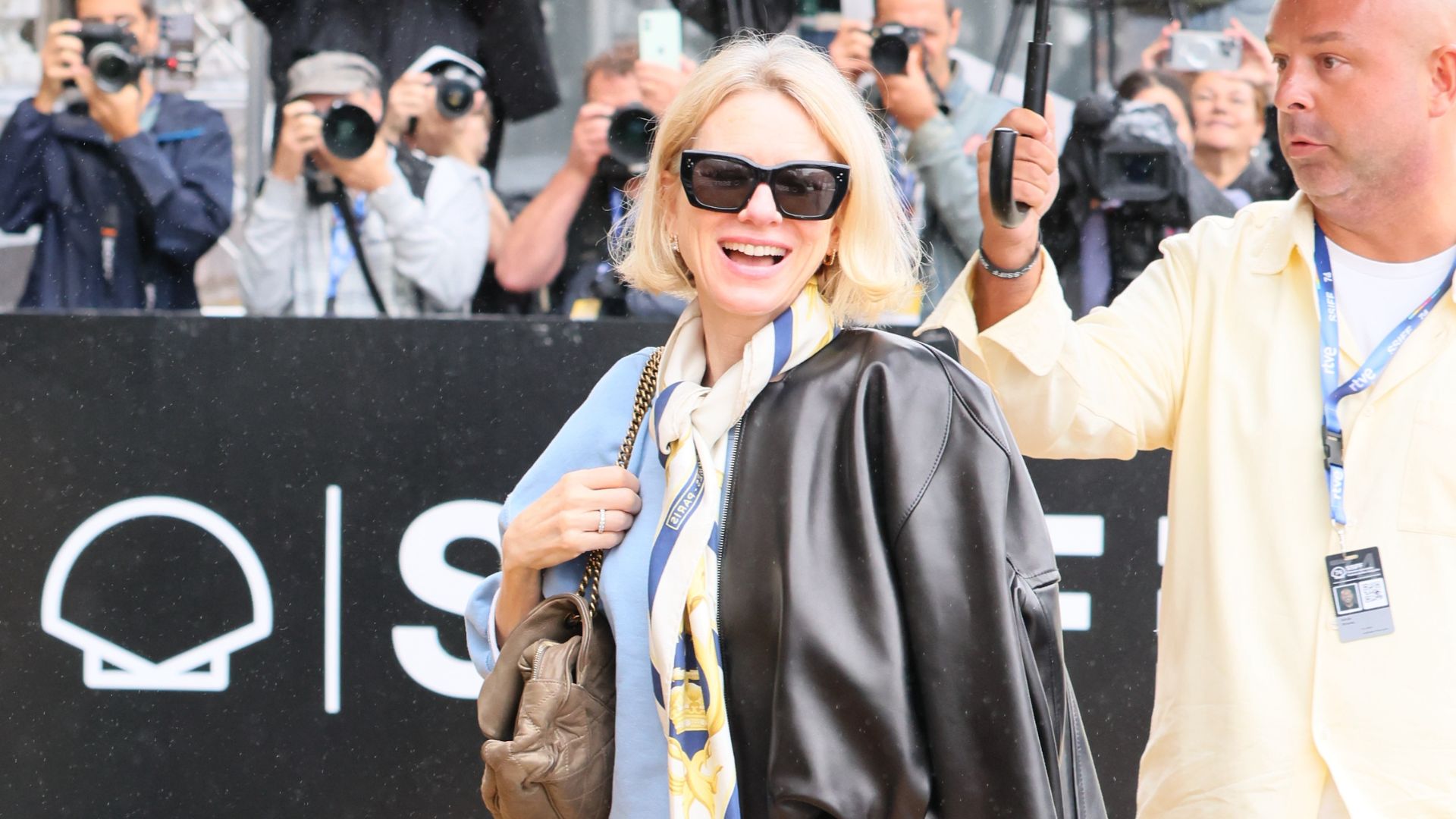 Naomi Watts in sunnies, pale blue sweater and scarf