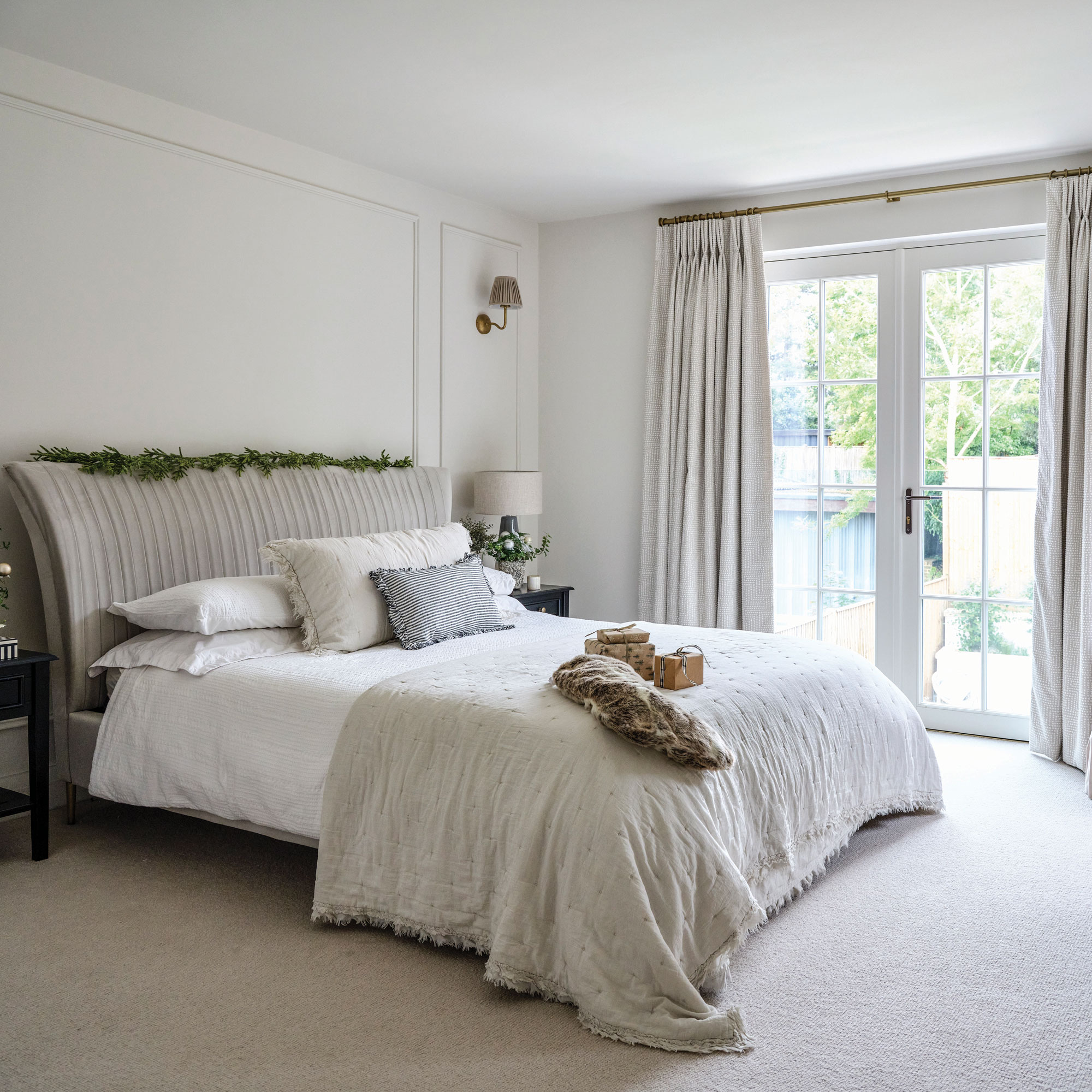 Beige bedroom with large double bed with large bay windows
