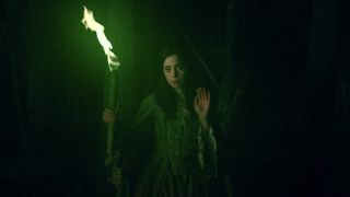 Screenshot of Death with green torch waving at Nicholas Scratch in Agatha All Along