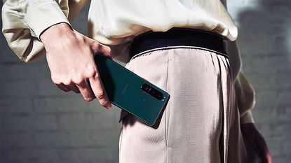 Sony Xperia 5 III Android phone being held by a man who is about to put the phone in his pocket