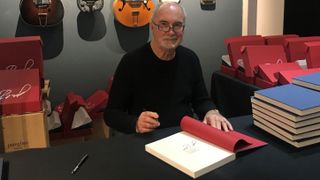 John Hall signing 'Rickenbacker Guitars: Out of the Frying Pan Into the Fireglo' copy at Shapero Rare Books' Rickenbacker exhibition in 2022