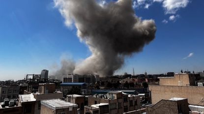 Smoke rises following a bombing run in Tehran, Iran.