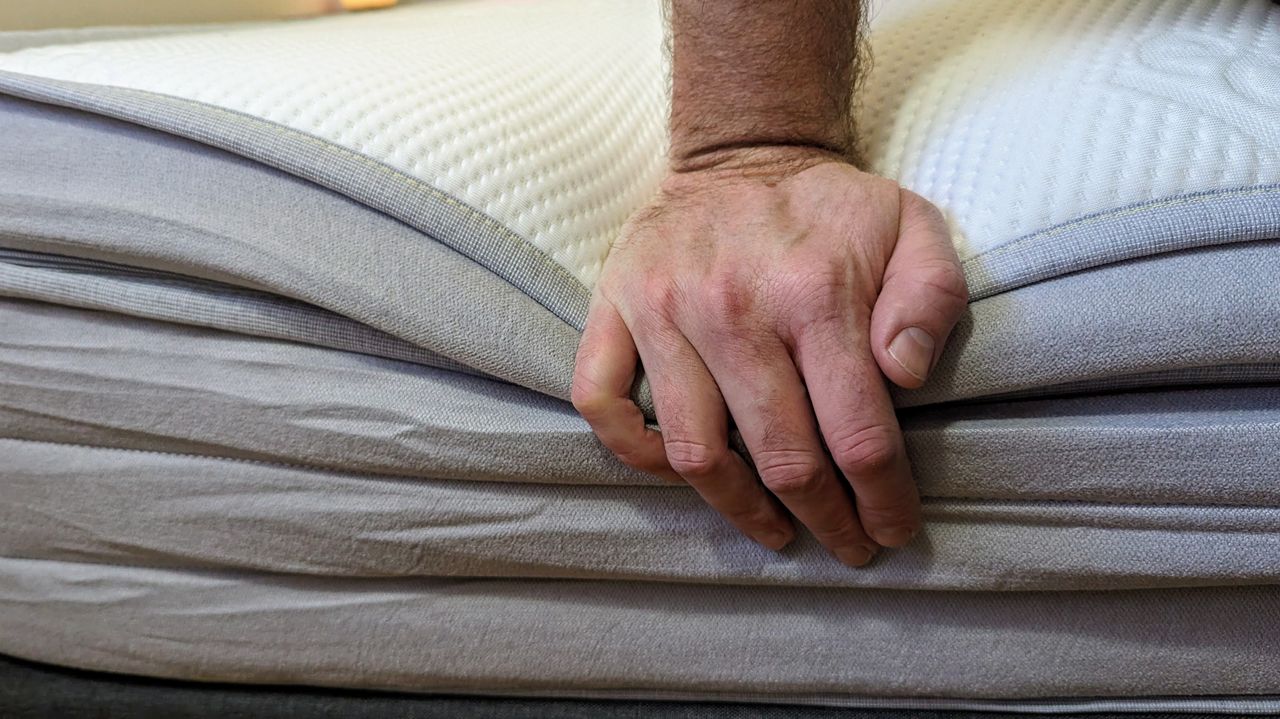 Ecosa Pure mattress showing edge support with hand
