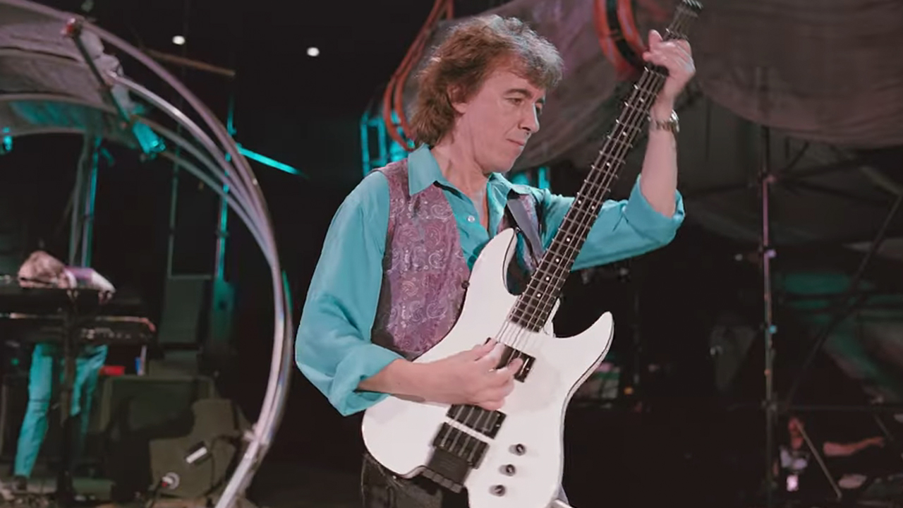 ステージで白いベースギターを弾くビル・ワイマン