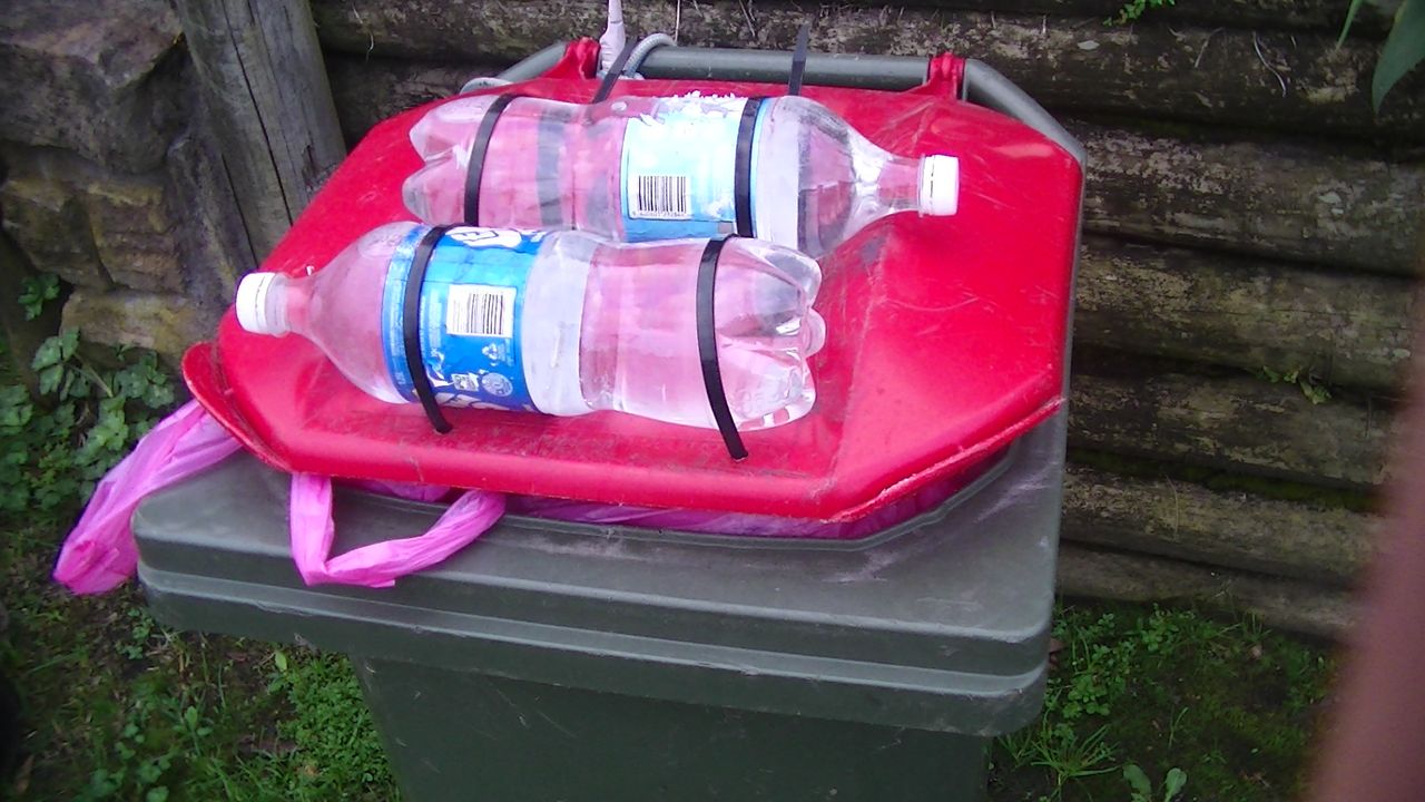 Another person tries to tape water bottles to their bin lid.
