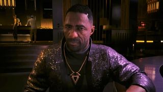 Idris Elba in Phantom Liberty looking at camera while seated at upscale restaurant