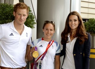 Catherine, Duchess of Cambridge (R) and Prince Harry (L) pose with gold medal winning rower Sophie Hosking (C) at Team GB House in the Westfield Centre, Stratford, east London