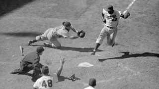 Catcher Toby Atwell scrambles for Dodger second baseman Jackie Robinson, who crosses home plate to score the winning run in the last half of the tenth inning at Ebbets Field on June 18th.