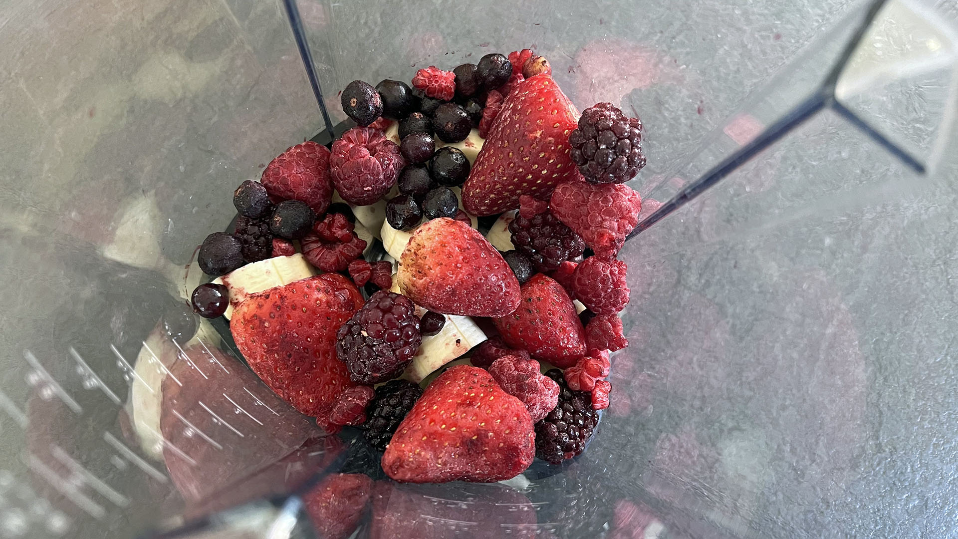 frozen berry smoothie ingredients in blender jug