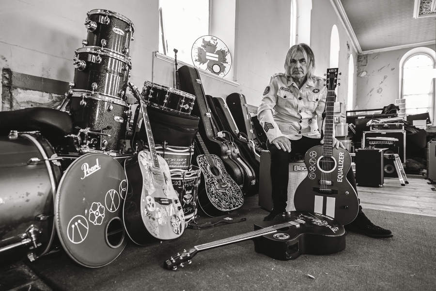 Mike Peters surrounded by musical equipment