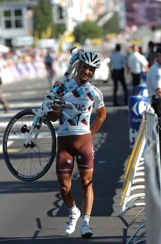 Lloyd Mondory (AG2R) carries his ruined bike across the line.