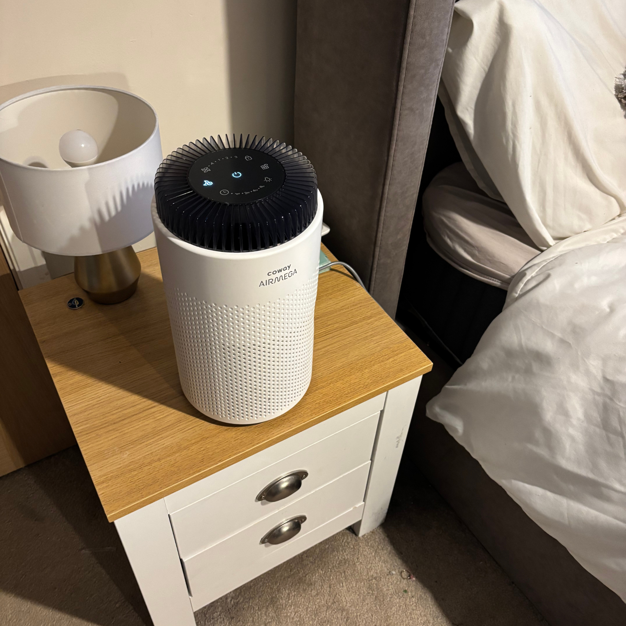 Coway Airmega 50 in sleep mode on bedside table