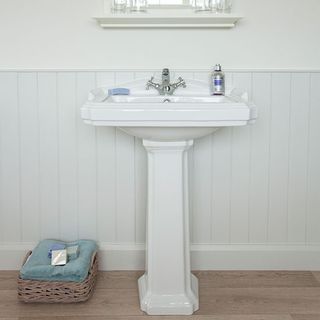 bathroom with white wall and washbasin and wooden floor