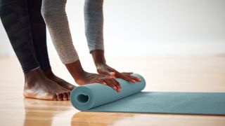 shot of a person rolling up their yoga mat