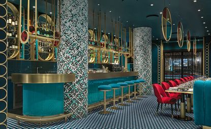 Liòn restaurant with teal, turquoise and red furnishing, columns and brass circles