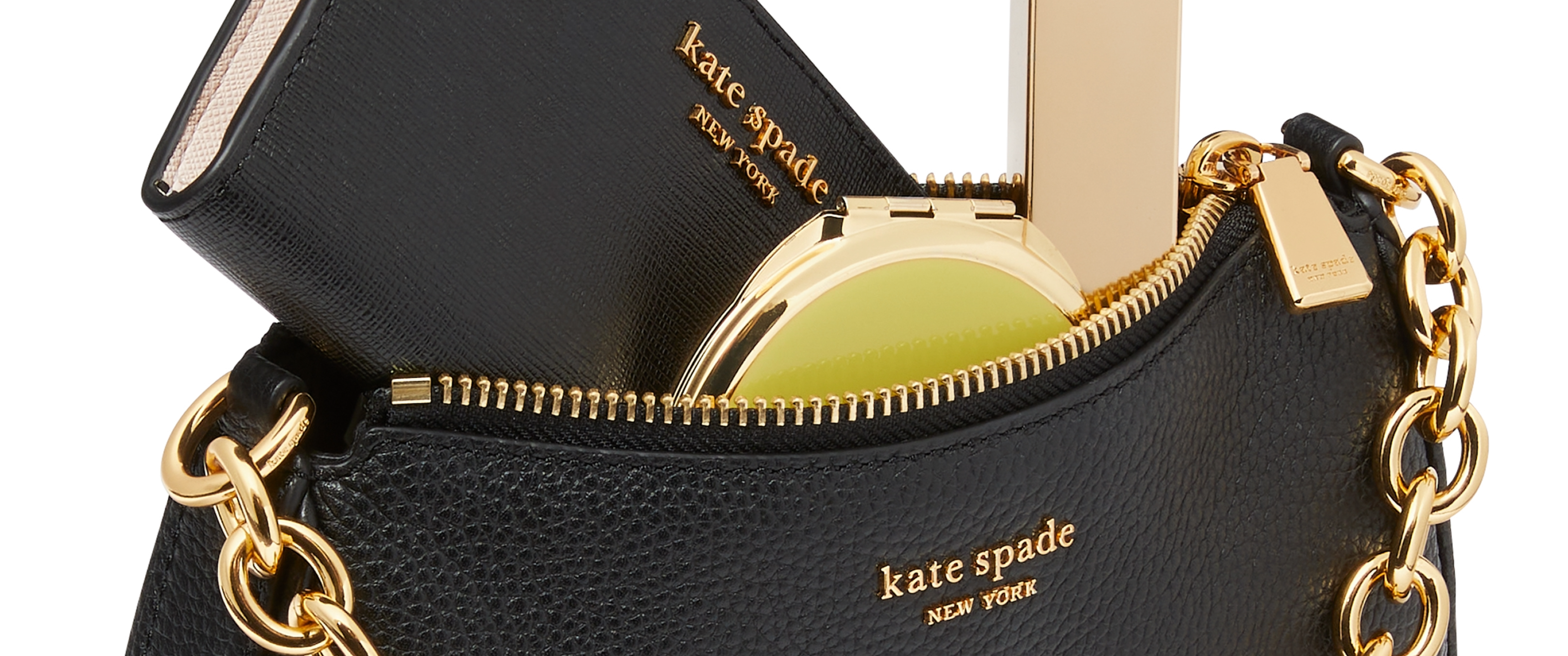 Black Kate Spade bag overflowing with makeup and a Kate Spade diary