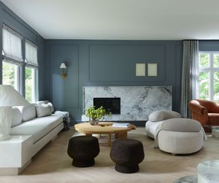living room with blue walls and white sofa and marble fireplace