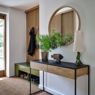 Hallway with black and natural wood console table with home decor and hanging mirror