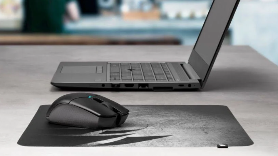 Corsair Katar Pro Wireless mouse on a desk next to a laptop