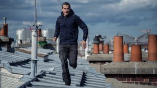 Franck (Guillaume Canet) runs across a rooftop in Netflix's "Ad Vitam"