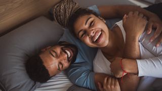 Two people hugging on a bed