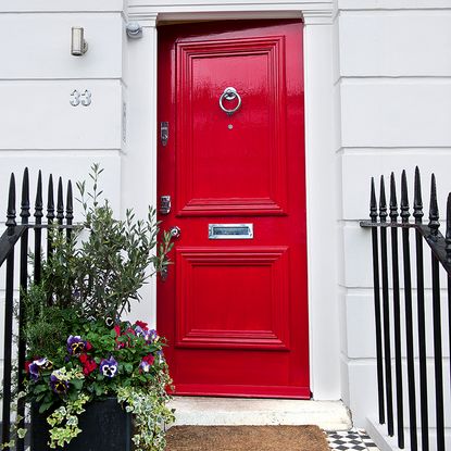house with red door and black iron fence