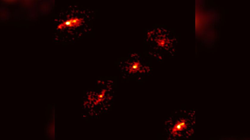 Five bright red lights glow in a cross formation in the darkness of space