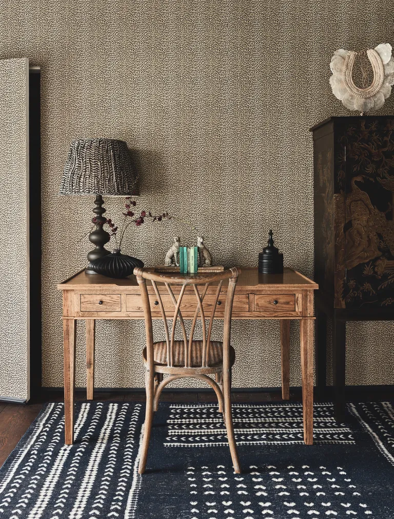 guest room office with desk and chair, leopard print wallpaper, vintage chinoiserie storage, black accessories