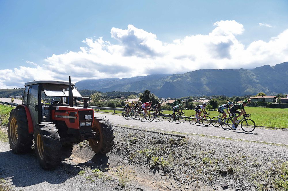 Riders pass a tractor during stage 15 of the Vuelta a Espana