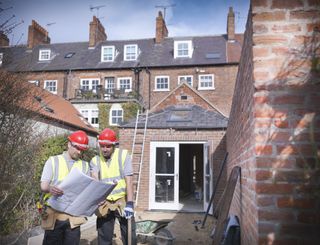 builders looking at plans outside of a home