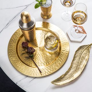 copper dinnerware with glasses and feather