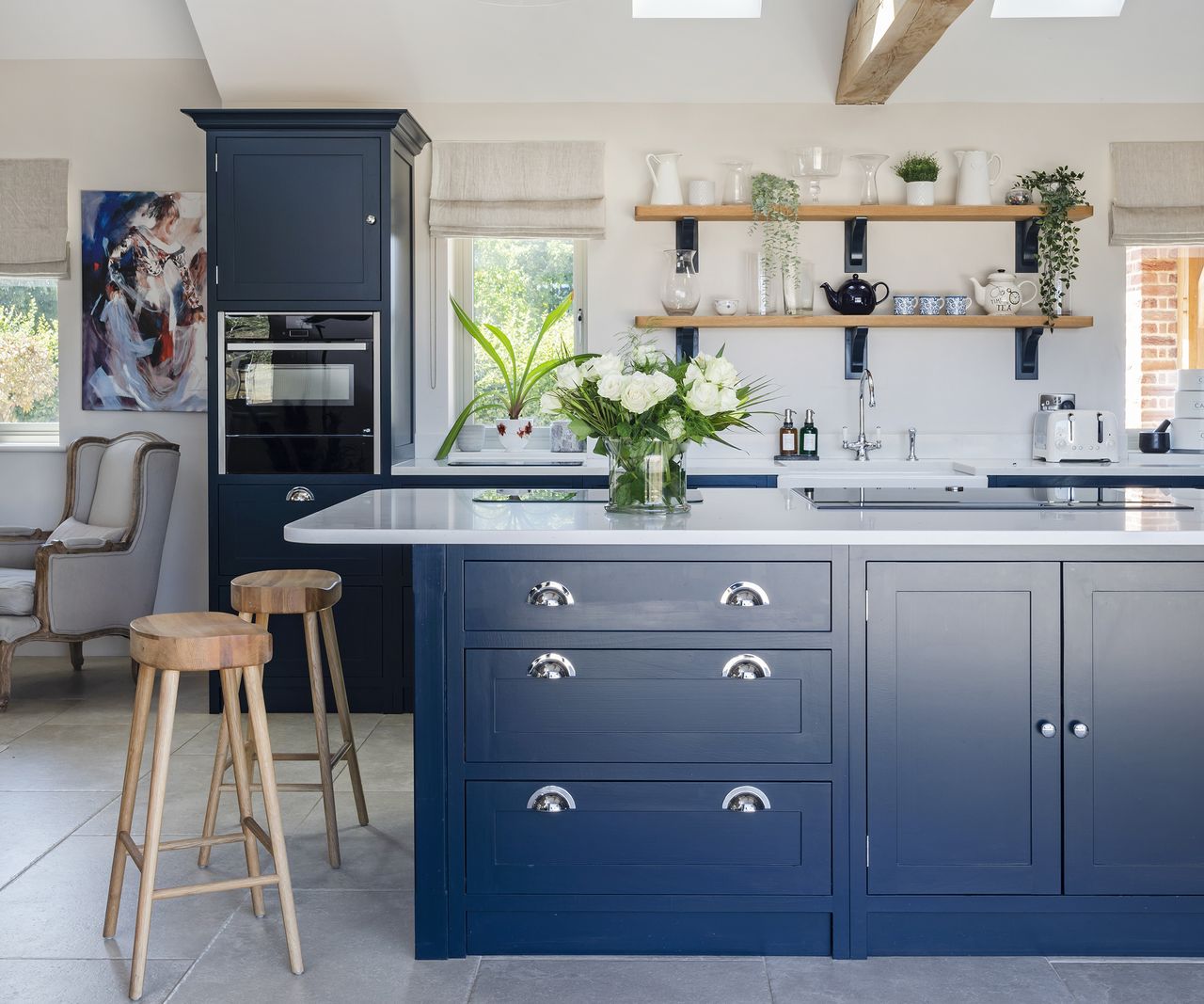 A navy Shaker kitchen with a kitchen island and bar stools