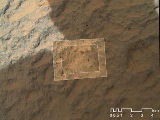 This image combines photographs taken by the Mars Hand Lens Imager (MAHLI) at three different distances from the first Martian rock that NASA's Curiosity rover touched with its arm.