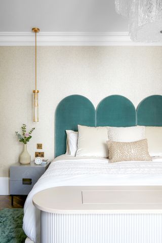 Bedroom with teal scalloped headboard and pendant bedside light