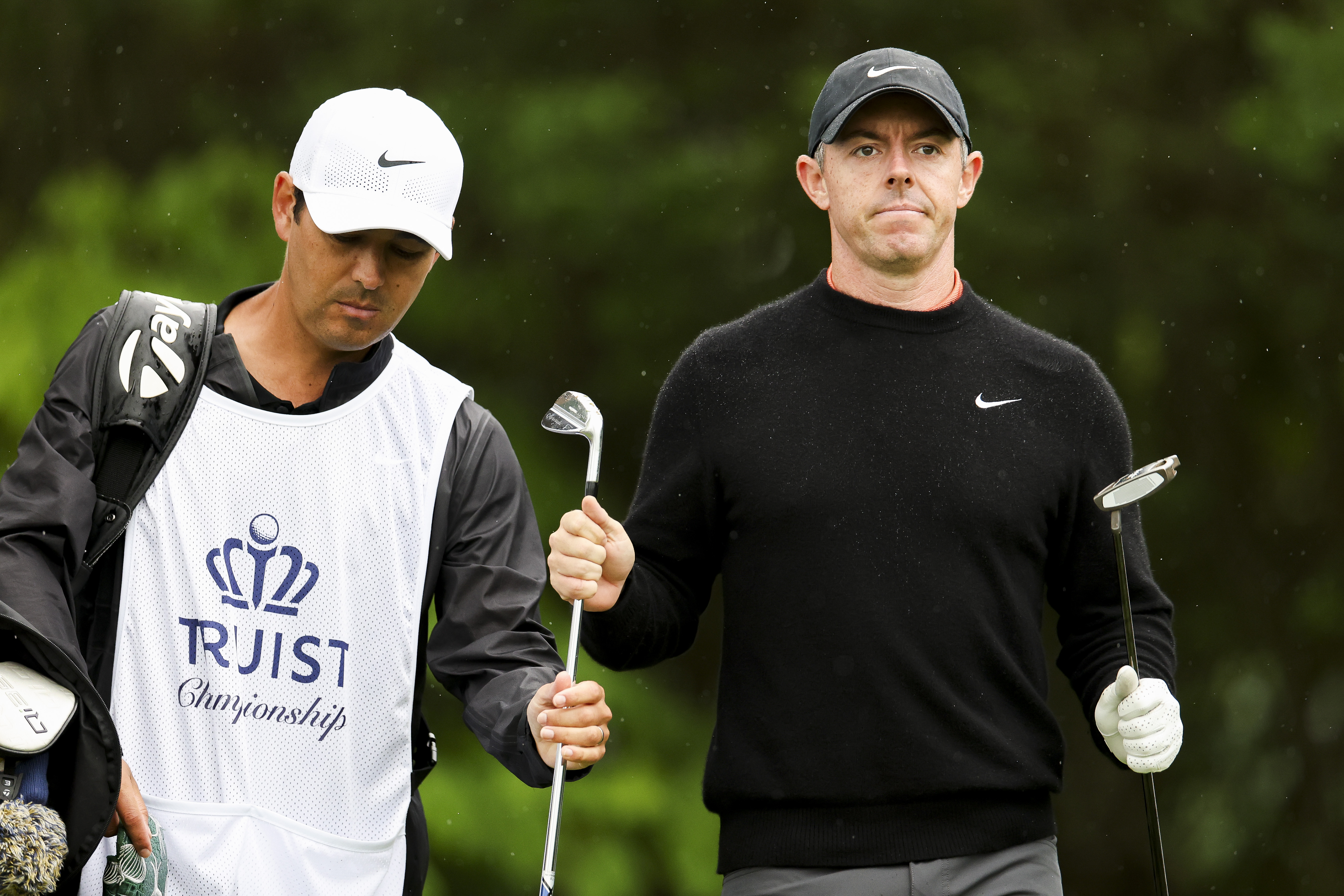 Rory McIlroy hands a club to his caddie